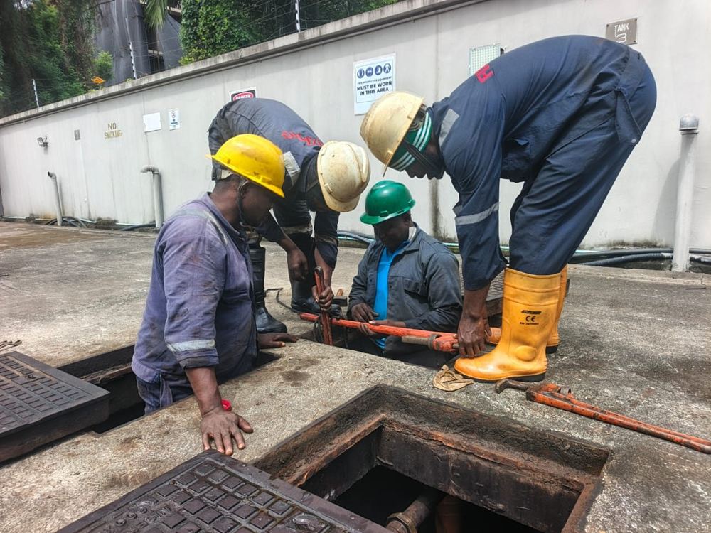 Fixpro technicians working on an underground fuel tank access chamber