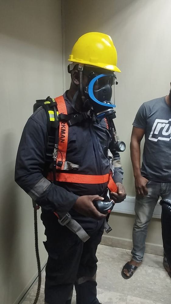 Technician in breathing apparatus preparing for confined space tank entry