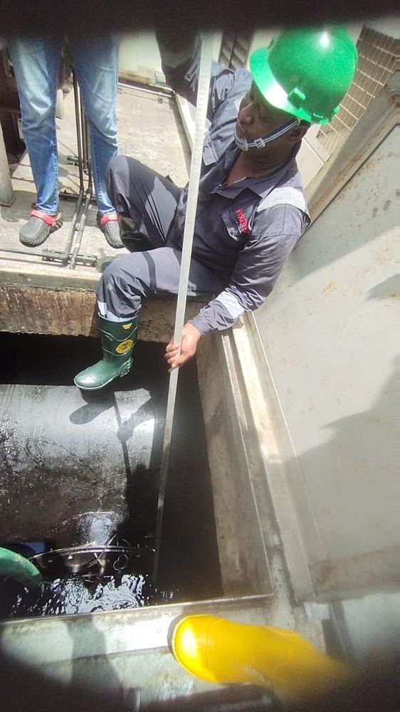 Technician gauging an underground diesel tank during servicing